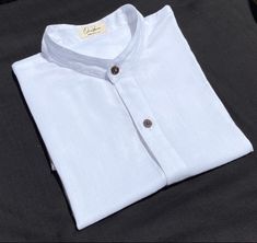 Mandarin collar shirt White  What distinguishes our shirt? There are several details that make our shirt unique. Like the rest of our collection, it is made of cotton and bamboo, two natural fibers that when put together give us a very soft texture. It is the shirt that you will not want to take off for its high comfort and freshness. Flax and bamboo have many benefits for the planet and for those who use them. Both materials are friendly to the skin, in addition to being hypoallergenic, they protect against UV rays. The buttons are made of shell. Every detail of this piece is natural, ecological and biodegradable. * Important: you can choose to order it in black, white, army green, gray / purple, brown and blue. * You can also indicate if you want it with a line or without a line and the Mandarin Collar Blouse, Mandarin Collar Shirt, Brown And Blue, Blouse White, Collar Blouse, Collar Shirt, Mandarin Collar, Soft Texture, White Linen