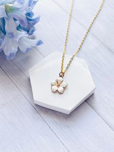 Gold Flower Necklace. Gold Flower Pendant With White Enamel on Gold Stainless Steel Chain, White Flower Pendant, Gold and White Necklace Available in chain lengths from 16 inches to 24 inches.  Each necklace is handmade and made to order It is recommended to not wear the necklace while sleeping and remove before exposing it to water, to avoid damage or tarnishing. This necklace is also available in blue, pink and purple.  You can see my other listings in my shop at: simplycreativegems.etsy.com White Flower Clavicle Chain Necklace, Elegant White Flower Necklace With Adjustable Chain, Dainty White Birth Flower Necklace, White Jewelry With Flower Charm And Shape, Delicate White Flower Charm Necklaces, White Flower Pendant Jewelry With Adjustable Chain, Delicate White Flower Charm Necklace, White Flower Necklace With Delicate Chain As Gift, White Flower Necklace With Delicate Chain For Gift