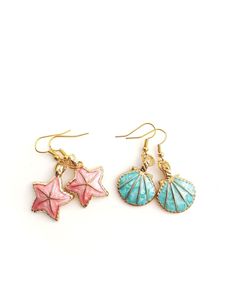 Sea shells/beach theme earrings in bright pretty colors! Pink starfish or blue shells with s shiny gold color as the base of the charms. Both earrings measure about 1.75 inches in length from top to bottom. Very cute & fun charm earrings, definitely eye-catching! Reminds me of what a mermaid might wear! Cheap Colorful Earrings For The Beach, Summer Starfish Charm Dangle Earrings, Summer Dangle Earrings With Starfish Charm, Gold Starfish Shell For Beach, Summer Beach Earrings With Starfish Charm, Beachy Gold Dangle Earrings, Gold Dangle Earrings For Beach Season, Summer Starfish Charm Drop Earrings, Starfish Charm Drop Earrings For The Beach