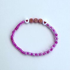 Handmade Beaded Bracelet. This bracelet is made with dainty multicolored beads, the beads are alternating shades of hot pink and light pink. It also features letter beads with the word "God" spelled out and hearts on both sides of the word. This bracelet is stretchy and will fit any size wrist. Handmade with love by yours truly 💞