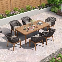 an outdoor dining table with chairs and plates on it