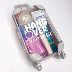 an open luggage bag with various items in it on a white surface and the words hang over travel kit