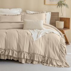 the comforter is made up with ruffles and pillows on top of it