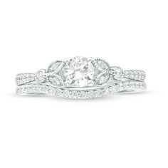 a white gold ring with an oval cut diamond surrounded by pave diamonds on the band