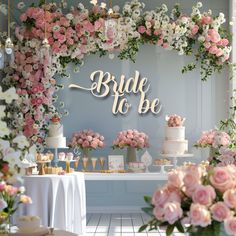 a table topped with lots of pink flowers and cake next to a sign that says bride to be