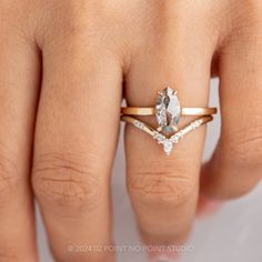 a woman's hand with a diamond ring on top of her finger and an engagement band