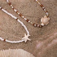 This boho-inspired necklace set features two layers of beads with charming starfish and turtle pendants. Perfect for beach lovers, it adds a touch of coastal charm to any outfit. 2-pack necklace set White & brown beaded design Lobster claw closure Adjustable size Turtle pendant beaded necklace size: 42cm (16.5inch) Strafish pendant beaded necklace size: 42cm (16.5inch) Bohemian Beaded Necklace With Starfish Charm For Beach, White Beaded Necklaces With Starfish Charm For Beach, Adjustable Necklace With Starfish Charm And Round Beads, Brown Summer Beach Necklaces, Brown Necklaces For Summer Beach, Bohemian Starfish Beaded Necklaces, Bohemian Beaded Starfish Necklace, Brown Necklaces For Summer Beach Occasions, Brown Beach Necklaces For Summer