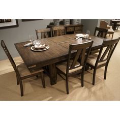 a dining room table with chairs and plates on it