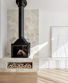 a fire place in the middle of a room with wood stacked on top of it