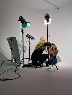 two women sitting in chairs with lights behind them