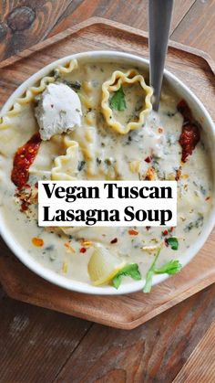 a bowl filled with ravioli and cheese on top of a wooden cutting board next to a spoon