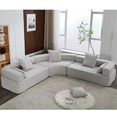 a living room with a large sectional couch in the middle and a white rug on the floor