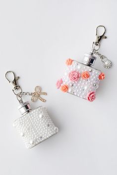 two keychains with flowers and pearls on them, one in the shape of a purse