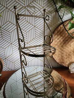 a metal shelf sitting on top of a table next to a basket filled with flowers