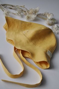 a yellow purse sitting on top of a white table next to some wildflowers