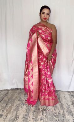 This stunning pink 100% Mulberry Katan silk saree is handwoven in Banaras, known for its intricate designs and high-quality craftsmanship. The saree features a beautiful shade of dual pink with gold and silver zari jaal work creating a mesmerizing effect. Loolong for a distinct saree - this is the one with silver zari outlining . The saree is perfect for any special occasion, such as a wedding, festival, or formal event. Comes finished with hand fall and Pico. And a blouse piece with zari border. Silk Mark Certified Note: Colors that show up on your screen may vary slightly from the actual product due to variations in settings. Also, the actual product may appear to be different hues depending on the ambience lighting.Note: There may be very slight inconsistencies such as in the weave/moti Transitional Pink Raw Silk Pre-draped Saree, Transitional Pink Saree With Zari Work, Pink Paithani Silk Pre-draped Saree For Traditional Ceremonies, Pink Bollywood Saree For Transitional Season, Bollywood Style Pink Saree For Transitional Season, Elegant Pink Pre-draped Saree With Zari Weaving, Transitional Pink Banarasi Silk Pre-draped Saree, Transitional Season Pink Banarasi Silk Pre-draped Saree, Pink Raw Silk Pre-draped Saree For Transitional Season