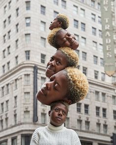 three women standing in front of a building with their heads stacked on top of each other