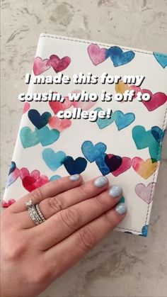 a woman's hand holding a notebook with hearts on it and the words i made this for my cousin who is off to college