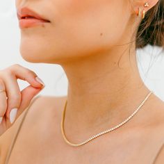 "Our White Crystal Pave Tennis Necklace features dozens of sparkly 2mm crystals along a stunning gold or silver chain. The perfect layering piece to have in your jewelry collection. DETAILS - 2mm white crystal pave stones - 15\" long with a 3\" extender - Available in 14kt gold plated or sterling silver See the matching bracelet here: https://etsy.me/3PE4sBR Packaging + Delivery: All items come packaged in a cute Amanda Deer Jewelry box and are sent in a protective bubble mailer. If ordering mul Gold Crystal Tennis Necklace With Sparkling Stones, Elegant Gold Tennis Necklace With Rhinestones, Elegant Everyday Crystal Necklaces, Gold Tennis Necklace With Diamond Accents And Crystal, Dainty Gold Rhinestone Jewelry, Gold Tennis Necklace With Rhinestones, Gold Cubic Zirconia Tennis Necklace With Sparkling Stones, Gold Tennis Necklace With Rhinestones And Cubic Zirconia, Gold Crystal Tennis Necklace For Wedding