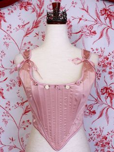 Be the star of the show with this gorgeous Renaissance to Baroque Era corset, this time in a special ballet pink satin! This piece features hand-sewn mauve and ivory rosette adornments, pink satin ribbon finishes, adjustable straps, and a classic Tudor Era design. Style it over a delicate dress or blouse with a puffy skirt for the perfect historically-inspired ballerina look. Sizing: ✧IN✧ Bust Waist S 30-34 Inches 24-28 Inches M 34-38 Inches 28-32 Inches L 38-42 Inches 30-34 Inches XL 40-44 Inches 36-40 Inches ✧CM✧ Bust Waist S 75-85 CM 60-70 CM M 85-95 CM 70-80 CM L 95-105 CM 75-85 CM XL 100-110 CM 90-100 CM Materials:10% Elastane 90% Polyester Care:Gently hand wash or dry clean only. Air dry only, hang or dry flat. Elegant Fitted Pink Corset, Feminine Fitted Pink Corset, Pink Feminine Underbust Corset, Pink Underbust Feminine Corset, Feminine Pink Underbust Corset, Pink Feminine Corset With Boned Bodice, Pink Fitted Wedding Corset, Fitted Pink Wedding Corset, Elegant Fitted Pink Bodice