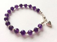 Rich, deep purple faceted amethysts with sterling silver beads and a sterling silver heart charm create a luxury bracelet.  The amethysts are of beautiful clarity and pure violet purple colour.  Amethyst is the birthstone of Aquarius, those born in February. A stunning bracelet, perfect as a special gift. Classy and elegant! Amethyst is called the 'All Healer' of gemstones, because of its soothing and healing properties! Length 19cm. Only one available.  Unique hand made bracelet with original d Spiritual Purple Sterling Silver Bracelet, Faceted Purple Amethyst Beaded Bracelets, Purple Amethyst Faceted Beaded Bracelets, Purple Faceted Amethyst Beaded Bracelets, Purple Sterling Silver Beaded Bracelets With Round Beads, Purple Gemstone Beaded Bracelets In Sterling Silver, Elegant Purple Bracelets With Heart Beads, Born In February, Moon Cat