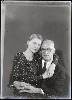 an old black and white photo of a man hugging a woman's head with her arm around him