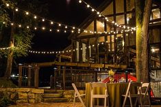 an outdoor dining area at night with string lights