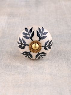 a white and black flower knob with gold center