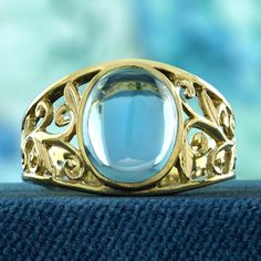 Enhance your style with this captivating vintage-inspired ring that exudes romance and sophistication. The delicate filigree work beautifully complements the smooth, oval cabochon blue topaz, creating an air of understated elegance. The warm, classic touch of yellow gold adds a timeless appeal, making this ring a perfect embodiment of feminine grace. Treat yourself to this graceful piece and experience a blend of vintage charm and contemporary allure. CHARACTERISTICS Status: Made to order Origin Luxury Round Topaz Ring With Filigree, Vintage Topaz Ring, Elegant Blue Oval Cabochon Moonstone Ring, Elegant Blue Topaz Cabochon Ring, Oval Cabochon Topaz Ring For Anniversary, Formal Oval Cabochon Topaz Ring, Anniversary Oval Cabochon Topaz Ring, Elegant Round Cabochon Topaz Ring, Oval Blue Topaz Filigree Ring For Formal Occasions