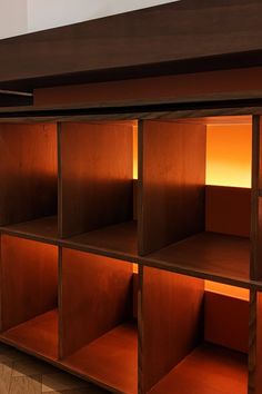 a wooden shelf with several open shelves on it's sides and light coming from the top