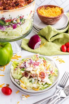 a salad is served in a bowl and on a plate with a fork, next to the salad