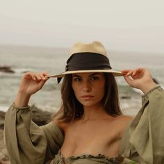 Natural straw fedora with broad brim and oversized black grosgrain band, wrapped asymmetrically around the hat and finished with a modern angular fold. 9cm brim length 9.5 cm crown height Hand Woven Panama Hat from Paja Toquilla straw Each hat is unique and reflects the natural beauty & variation of the handicraft process Small/Medium (55 cm - 57 cm), Large (58 - 59 cm) Spring Straw Panama Hat With Structured Crown, Elegant Panama Hat With Structured Crown, Structured Crown Toquilla Straw Panama Hat For Summer, Summer Structured Crown Panama Hat In Toquilla Straw, Summer Panama Hat With Structured Crown In Toquilla Straw, Adjustable Straw Panama Hat With Structured Crown, Summer Structured Crown Toquilla Straw Hat, Chic Fitted Hat For The Beach, Chic Fitted Beach Hat