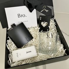 a black box containing a flask, lighter and other items for men's grooming