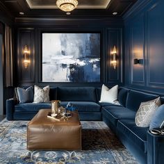 a living room filled with blue couches and pillows in front of a large painting