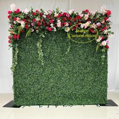 a green wall covered in flowers and greenery