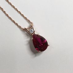 "Beautiful Ruby & White Sapphire Pendant Necklace set in 14k Rose Gold * Pear Cut Ruby measures 10x7mm * Single Brilliant Cut White Sapphire Accent measures 2.5mm * 2.7cts total Gemstone weight * 16\" or 18\" Chain Included * 14k Rose Gold Also Available in Sterling Silver or 14kt Yellow or White Gold - message me for details Hallmarked & Gift Ready! Matching Earrings & Ring Available This Ruby is laboratory grown. It is identical to natural in every way, including Chemistry, Composition and Har Rose Gold Pear-shaped Gemstone Necklaces, Rose Gold Pear-shaped Gemstone Necklace, Pear-shaped Rose Gold Jewelry With Brilliant Cut, Pear-shaped Brilliant Cut Rose Gold Jewelry, Fine Jewelry Pear-shaped Rose Gold Necklace, Fine Jewelry Rose Gold Pear-shaped Necklace, Rose Gold Jewelry With Prong Setting Drop Shape, Rose Gold Pear-shaped Jewelry With Prong Setting, Rose Gold Pear-shaped Ruby Jewelry