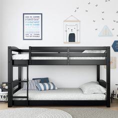 a black bunk bed sitting in a bedroom next to a wall with pictures on it