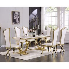 a white and gold dining room set with chairs, table and vase on the rug