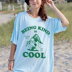 Being Kind Is Cool Shirt - Be a cool and kind human in this trendy, retro style, unisex, comfort colors shirt. SIZING Please size up for the over-sized look, refer to the size chart in the final image for the perfect fit. MATERIALS Comfort Colors are the ultimate when it comes to soft and comfortable Tshirts. They are made from 100% ring-spun cotton. The soft-washed, garment-dyed fabric brings extra coziness to your wardrobe while the relaxed fit makes it an excellent daily choice. They are high Casual Relaxed Fit Shirt With Cartoon Print, Cool Summer T-shirt With Letter Print, Trendy Blue Pre-shrunk T-shirt, Cool Crew Neck Tops For Summer, Cool Crew Neck Summer Tops, Cool Summer Tops With Crew Neck, Trendy Cartoon Print Shirt For Streetwear, Trendy Short Sleeve Shirt With Letter Print, Casual Blue Shirt With Cartoon Print