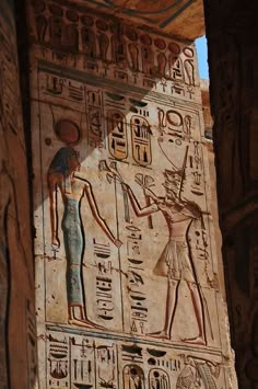 an ancient egyptian wall painting on the side of a building with two people holding hands