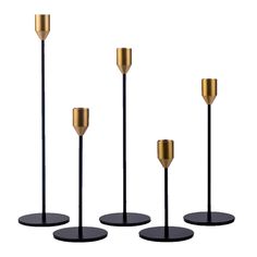 three black and gold candlesticks are shown in front of the same candle holder