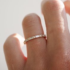 a woman's hand with a diamond ring on her left hand and the other hand holding it