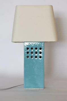 a blue lamp with a white shade on it