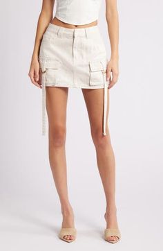 This casual-cool denim skirt features cargo pockets with drapey ring belts for a modern utilitarian vibe. Zip fly with button closure Five-pocket style Cargo flap-patch pockets 97% cotton, 30% lyocell Hand wash, line dry Imported Trendy Mini Cargo Skirt With Pockets, Trendy Mini Cargo Skirt With Belt Loops, Chic Cotton Cargo Skirt For Spring, Summer Utility Style Mini Length Bottoms, Summer Utility Bottoms Mini Length, Summer Utility Mini Bottoms, Chic Mini Cargo Skirt With Pockets, Chic Mini Length Cargo Skirt With Pockets, Spring Mini Bottoms With Patch Pockets