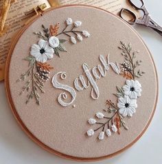 an embroidery kit with the word saffron on it next to some scissors and a book