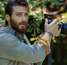 a man with a beard holding a camera