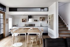 an open kitchen and living room with stairs leading up to the second floor in this modern home