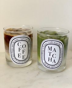 two glasses filled with liquid sitting next to each other on top of a white counter