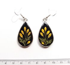 two pairs of earrings with yellow flowers painted on them