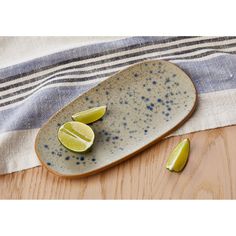 two lime slices on a plate with a towel in the background